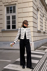 a lady wears a fluffy striped cardigan with black straight pants